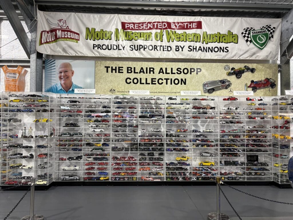 Banner showing Blair Allsop photo and text - Blair Allsop Collection above cabinets against a wall full of scale model cars